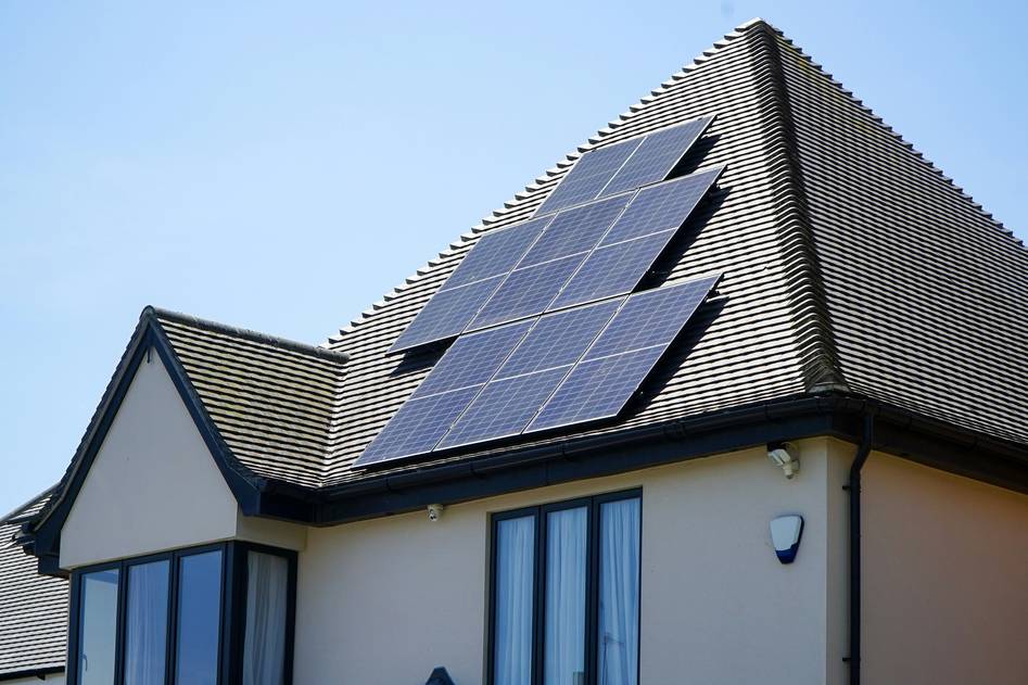 Close-up of solar panel wiring installation on a rooftop with labeled DC connectors and conduit